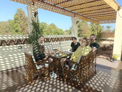 a group of people sitting at a table on a patio at Nubian Soul Guest Houses in Aswan