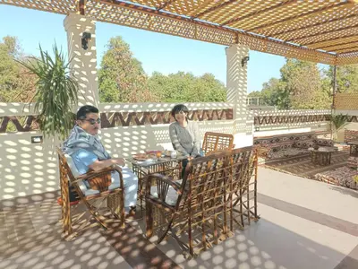 two people sitting at a table on a patio at Nubian Soul Guest Houses in Aswan