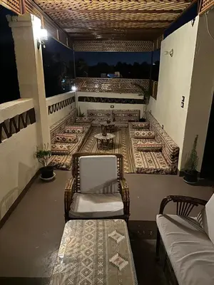 a balcony with a couch and a chair on a porch at Nubian Soul Guest Houses in Aswan