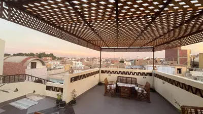 a balcony with a table and chairs on a building at Nubian Soul Guest Houses in Aswan