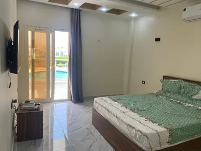 a bedroom with a bed and a view of a pool at Sky star 135 in Hurghada