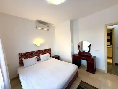 a bedroom with a white bed and a mirror at Amazing 2BR Apartment - Al Dora Resort, Hurghada in Hurghada