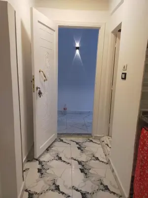a door leading into a room with a cross on the wall at Dolphin guest house in Jazīrat al ‘Awwāmīyah