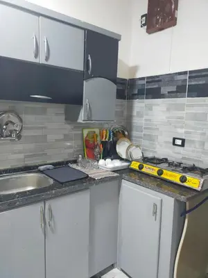 a kitchen with white cabinets and a counter top at Dolphin guest house in Jazīrat al ‘Awwāmīyah