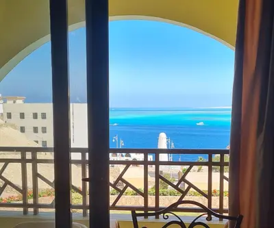 a room with a view of the ocean from a balcony at The View in Hurghada