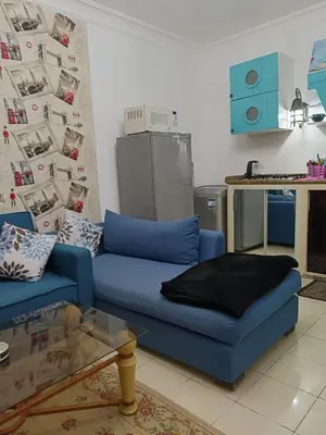 a living room with a blue couch and a kitchen at The View in Hurghada