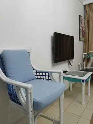 a blue chair sitting next to a desk with a tv at The View in Hurghada