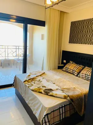 a bedroom with a bed and a view of a patio at Cozy and spacious apartment for family , view sea in Hurghada