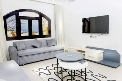 a living room with a couch and a table and a tv at Cozy and spacious apartment for family , view sea in Hurghada