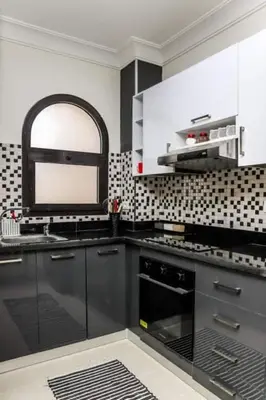 a kitchen with black cabinets and a black oven at Cozy and spacious apartment for family , view sea in Hurghada