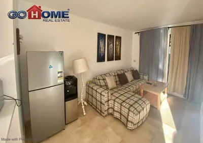 a living room with a couch and a refrigerator at Stylish 1 Bedroom at Scarab - El-Gouna WS14 in Hurghada