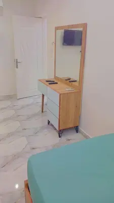 a dresser with a mirror on top of it at Memo home in Jazīrat al ‘Awwāmīyah