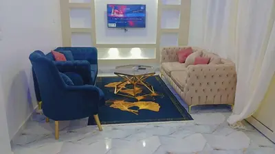 a living room with two chairs and a couch at Memo home in Jazīrat al ‘Awwāmīyah