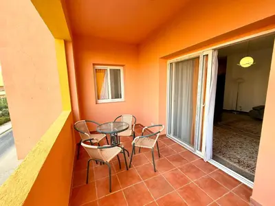 a small balcony with a table and chairs on it at Stunning 2BR Apartment - Al Dora Resort, Hurghada in Hurghada