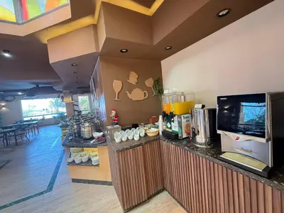 a food counter in a restaurant with a tv at Stunning 2BR Apartment - Al Dora Resort, Hurghada in Hurghada