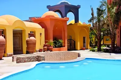 a resort with a swimming pool in front of a building at Stunning 2BR Apartment - Al Dora Resort, Hurghada in Hurghada