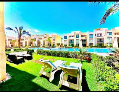 a resort yard with chairs and a swimming pool at One bedroom in gouna in Hurghada