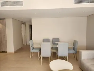 a dining room with a table and chairs and a couch at Elgouna - Mangroovy 2BR - Pool & Sea view in Hurghada