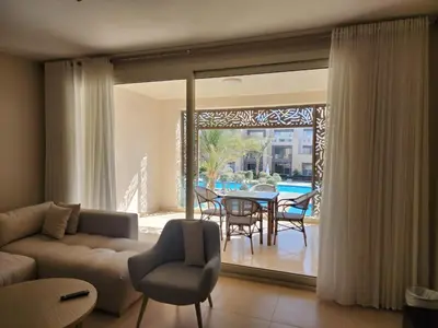 a living room with a couch and a table and chairs at Elgouna - Mangroovy 2BR - Pool & Sea view in Hurghada