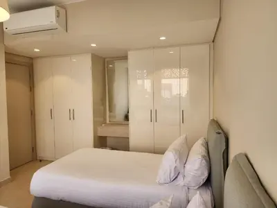a bedroom with a bed and white cabinets at Elgouna - Mangroovy 2BR - Pool & Sea view in Hurghada