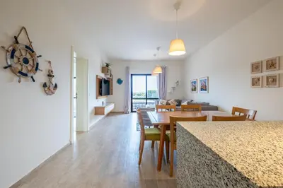 a dining room and living room with a table and chairs at Fanadir 3BR • Prime Sea View Villa in Hurghada