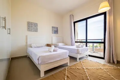 a bedroom with two beds and a large window at Fanadir 3BR • Prime Sea View Villa in Hurghada