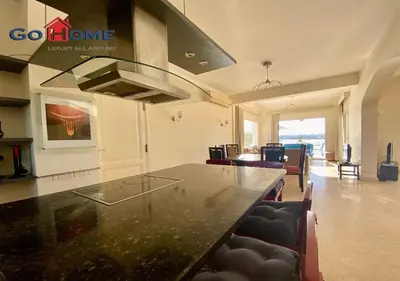 a kitchen with a black counter top and chairs at Stylish 4 BR with a Private Heated Pool V15 at White Villas in Hurghada