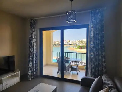 a living room with a view of a balcony at Gouna - Tawila 1BR breathtaking lagoon & pool view in Hurghada