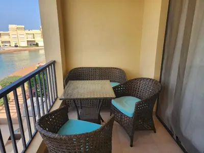 a balcony with a table and chairs on a balcony at Gouna - Tawila 1BR breathtaking lagoon & pool view in Hurghada
