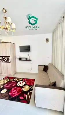 a living room with a couch and a tv at Cozy studio G-cribs in Hurghada