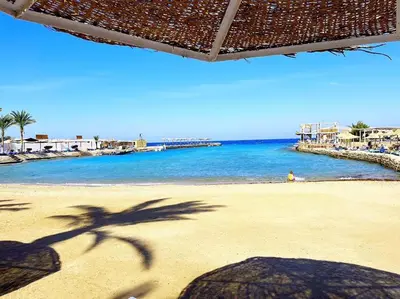 a shadow of a palm tree on a beach at New Geisum Resort in Hurghada