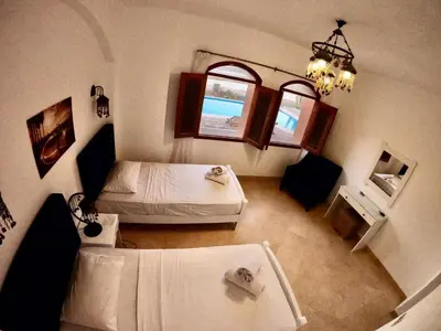 a small room with two beds and a window at Villa 3bedroom in new years in Hurghada