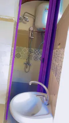 a bathroom with a white sink and a shower at waleed home in Jazīrat Aswān
