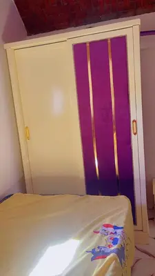 a bed in a room with a purple door at waleed home in Jazīrat Aswān