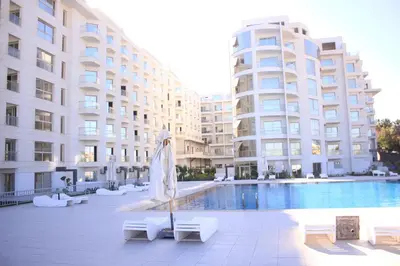 a large building with a pool and a umbrella at سكانديك ريزورت - Scandic resort in Hurghada