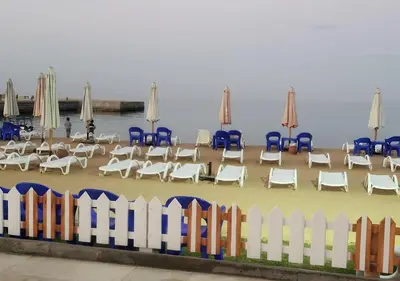 a beach with chairs and tables and umbrellas at Juliana beach resort in Hurghada