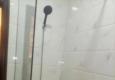 a shower with a black shower head in a bathroom at Juliana beach resort in Hurghada