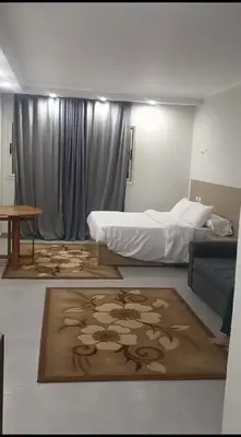 a bedroom with a bed and a table and a rug at Scandic resort hurghada in Hurghada