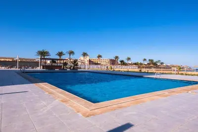 a swimming pool in a resort with palm trees at Scandic resort hurghada in Hurghada