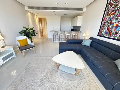 a living room with a blue couch and a table at luxury ancient stands resort one bedroom in Hurghada