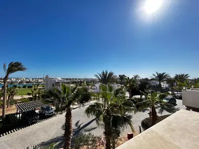 a view of a beach with palm trees and a building at luxury ancient stands resort one bedroom in Hurghada