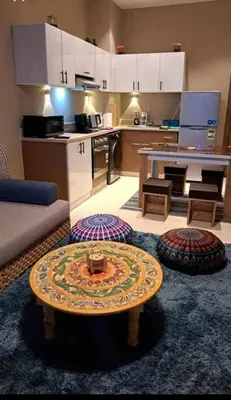 a living room with a table and a kitchen at Makadi Heights in Hurghada