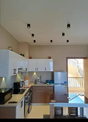 a kitchen with white cabinets and a counter top at Makadi Heights in Hurghada