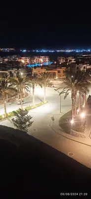 a city at night with palm trees and lights at Makadi Heights in Hurghada