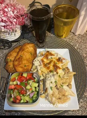 a table topped with a plate of food and a salad at City center NewAswan in Aswan
