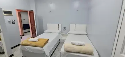 a white room with two beds and a mirror at City center NewAswan in Aswan