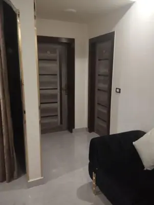 a living room with two doors and a black couch at City center NewAswan in Aswan