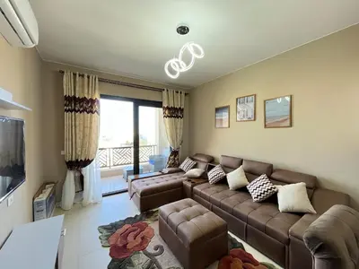 a living room with a couch and a tv at Makadi heights - phase 2 in Hurghada