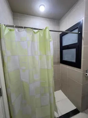 a shower curtain in a bathroom with a window at Makadi heights - phase 2 in Hurghada
