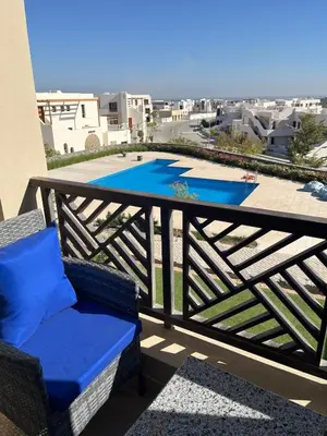 a balcony with two chairs and a swimming pool at Makadi heights - phase 2 in Hurghada